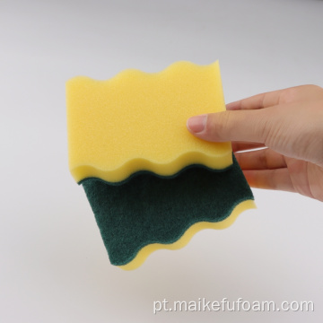 Limpando a almofada de limpeza verde de esponja amarela para cozinha